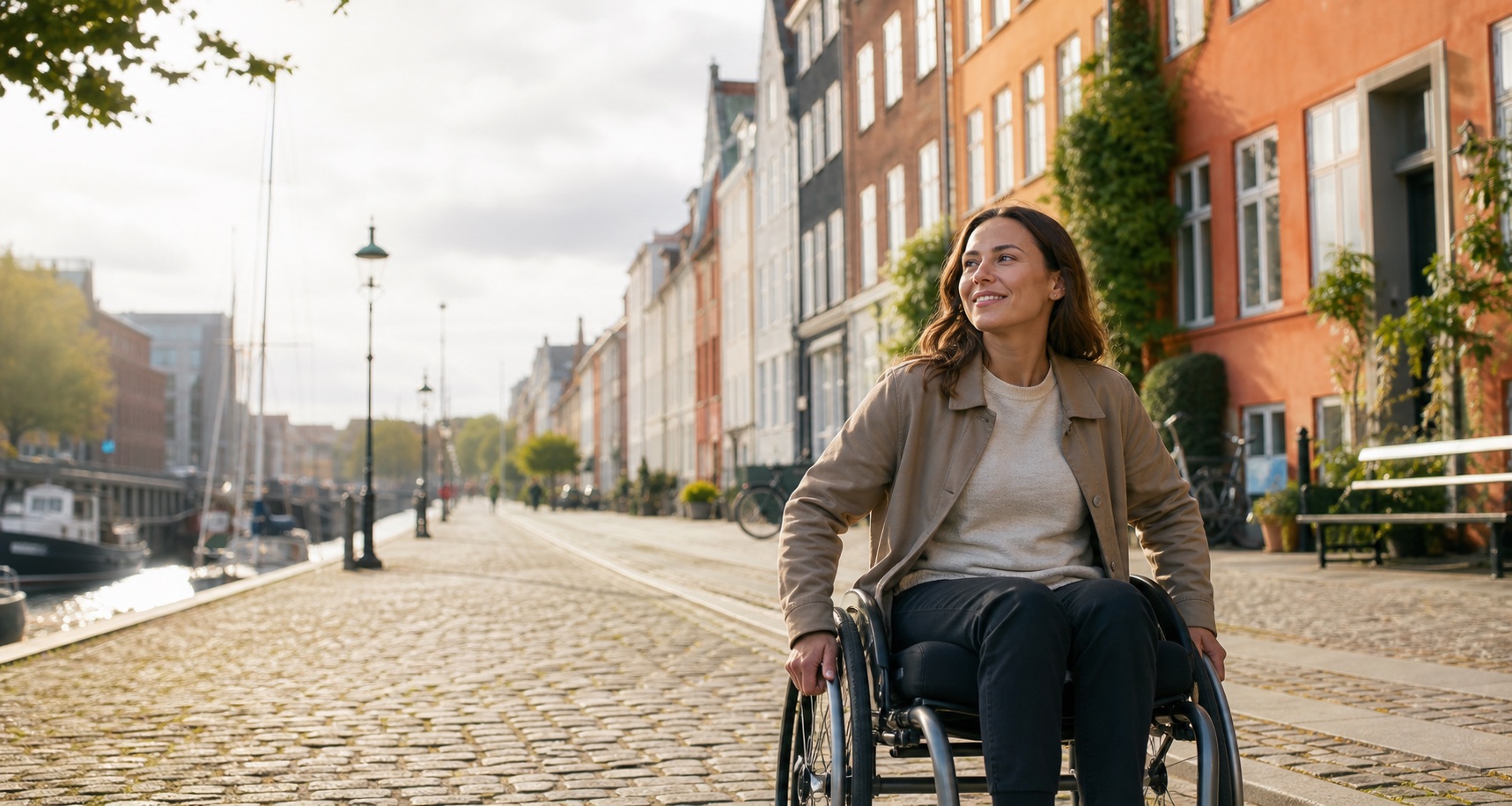 A woman using a wheelchair enjoying a sunny canal-side street